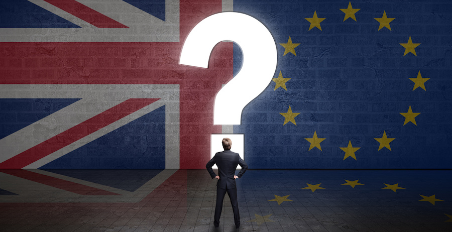 Portal in Form eines Fragezeichens in einer Wand mit UK- und EU-Flagge